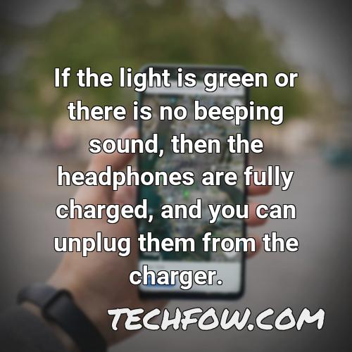 if the light is green or there is no beeping sound then the headphones are fully charged and you can unplug them from the charger