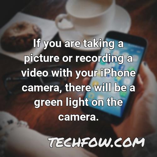 if you are taking a picture or recording a video with your iphone camera there will be a green light on the camera