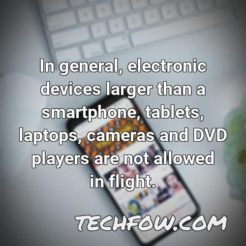 in general electronic devices larger than a smartphone tablets laptops cameras and dvd players are not allowed in flight