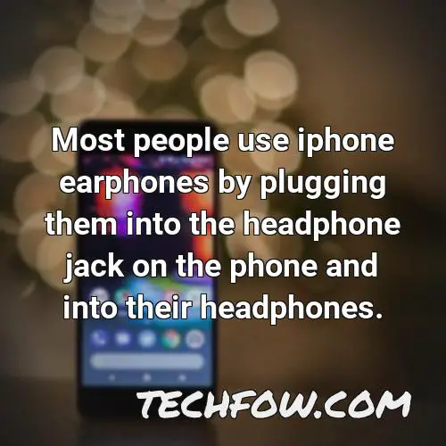 most people use iphone earphones by plugging them into the headphone jack on the phone and into their headphones