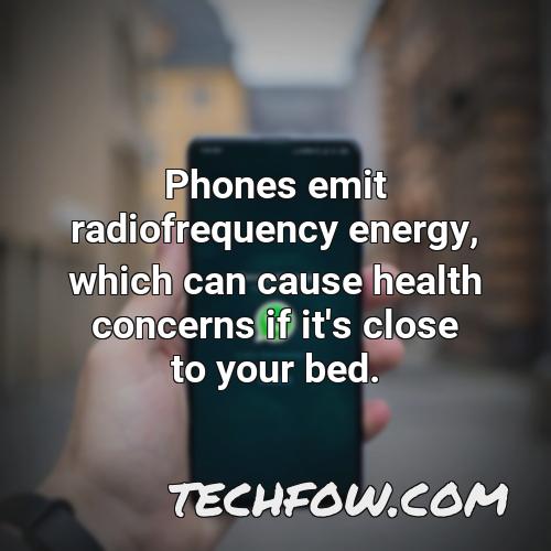 phones emit radiofrequency energy which can cause health concerns if it s close to your bed