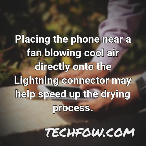 placing the phone near a fan blowing cool air directly onto the lightning connector may help speed up the drying process