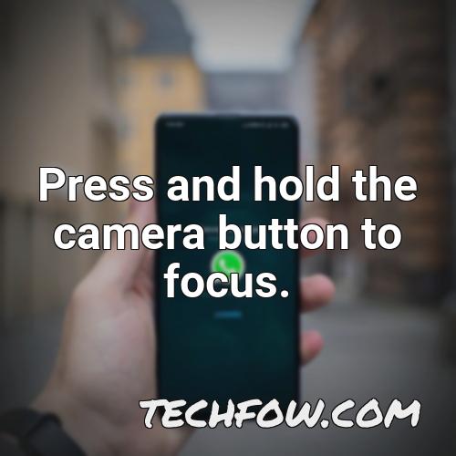 press and hold the camera button to focus