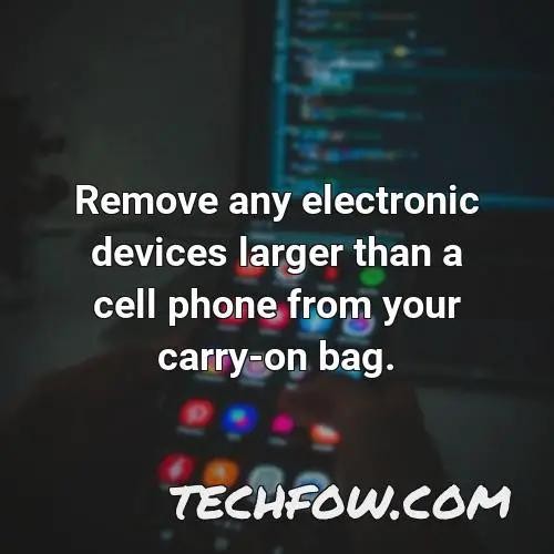remove any electronic devices larger than a cell phone from your carry on bag