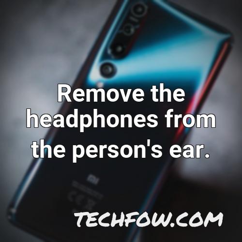 remove the headphones from the person s ear