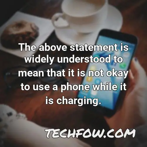 the above statement is widely understood to mean that it is not okay to use a phone while it is charging