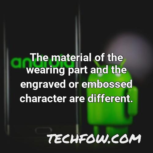 the material of the wearing part and the engraved or embossed character are different