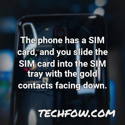 the phone has a sim card and you slide the sim card into the sim tray with the gold contacts facing down