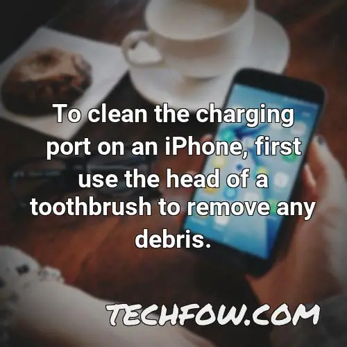 to clean the charging port on an iphone first use the head of a toothbrush to remove any debris