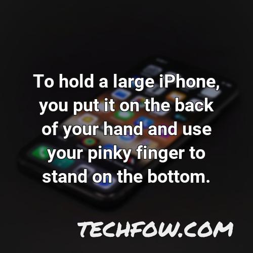 to hold a large iphone you put it on the back of your hand and use your pinky finger to stand on the bottom