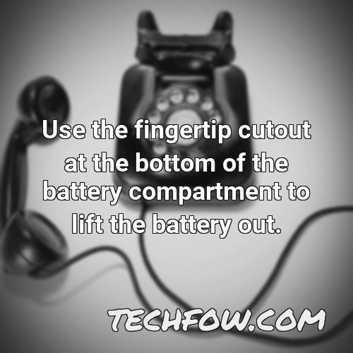 use the fingertip cutout at the bottom of the battery compartment to lift the battery out