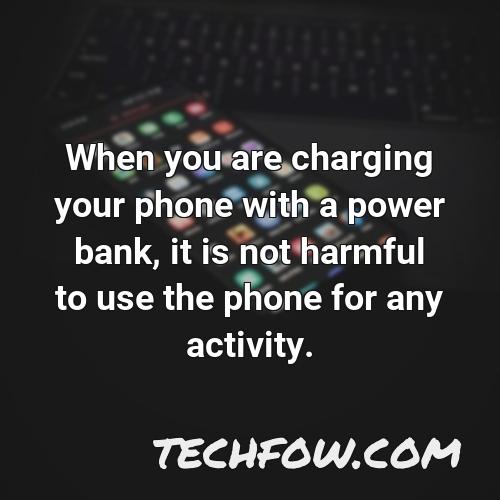 when you are charging your phone with a power bank it is not harmful to use the phone for any activity
