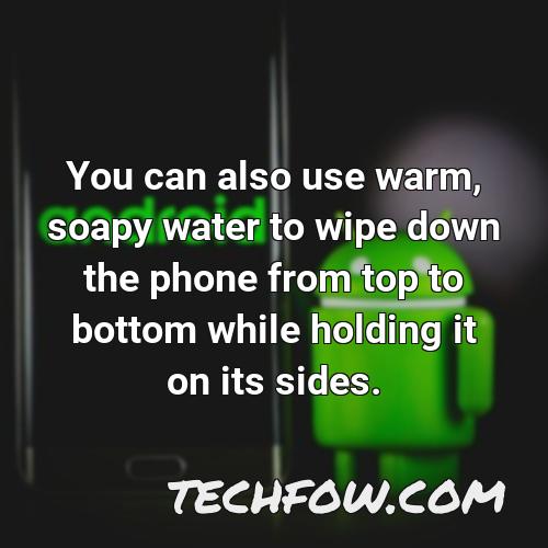 you can also use warm soapy water to wipe down the phone from top to bottom while holding it on its sides
