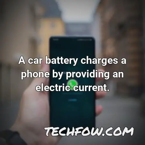 a car battery charges a phone by providing an electric current