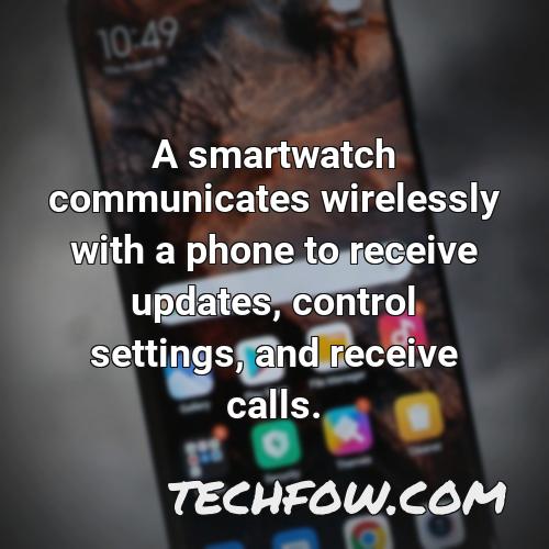 a smartwatch communicates wirelessly with a phone to receive updates control settings and receive calls