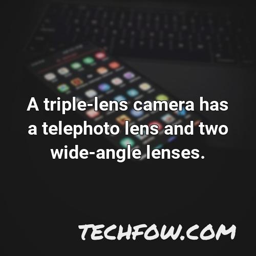 a triple lens camera has a telephoto lens and two wide angle lenses