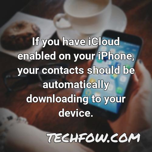 if you have icloud enabled on your iphone your contacts should be automatically downloading to your device