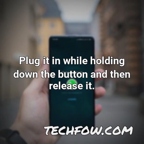 plug it in while holding down the button and then release it