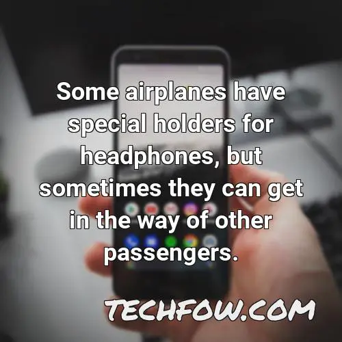 some airplanes have special holders for headphones but sometimes they can get in the way of other passengers