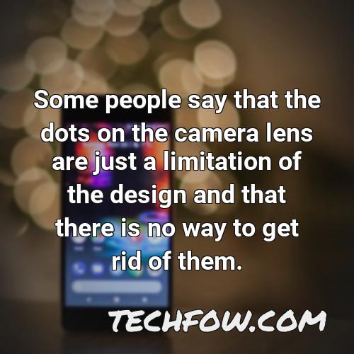 some people say that the dots on the camera lens are just a limitation of the design and that there is no way to get rid of them