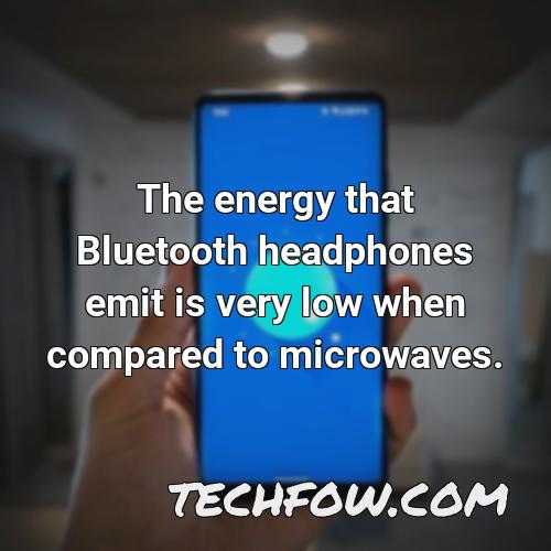 the energy that bluetooth headphones emit is very low when compared to microwaves