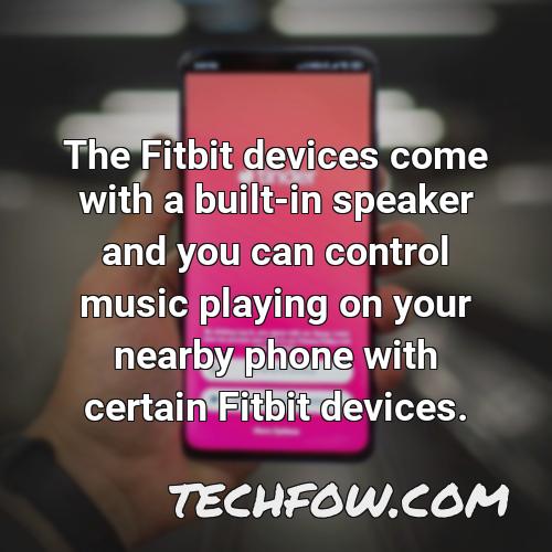 the fitbit devices come with a built in speaker and you can control music playing on your nearby phone with certain fitbit devices