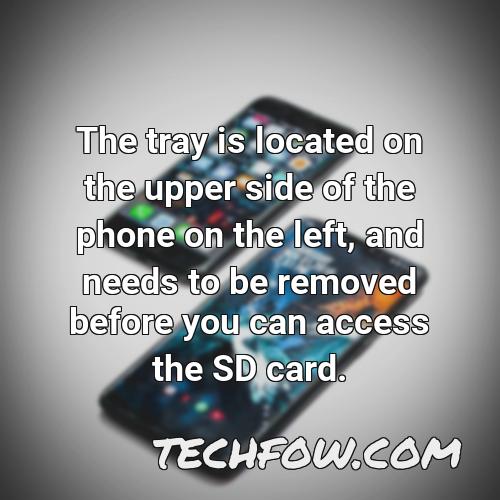 the tray is located on the upper side of the phone on the left and needs to be removed before you can access the sd card