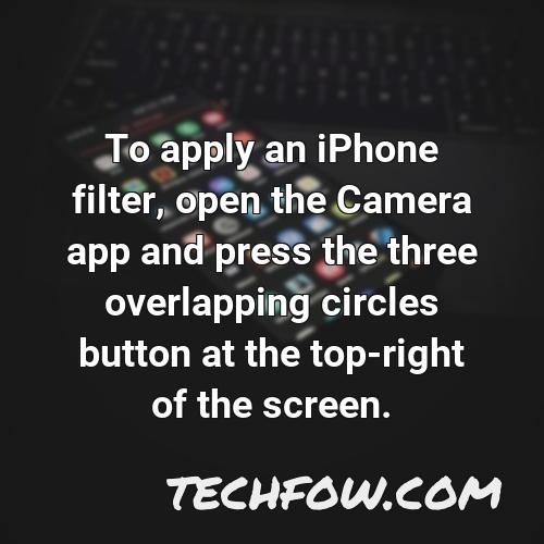 to apply an iphone filter open the camera app and press the three overlapping circles button at the top right of the screen
