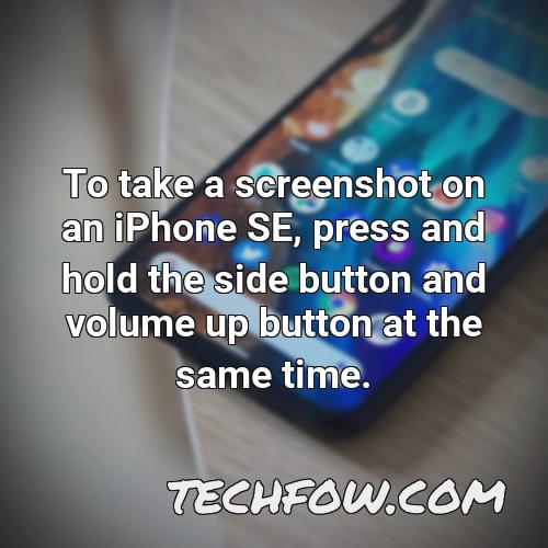 to take a screenshot on an iphone se press and hold the side button and volume up button at the same time