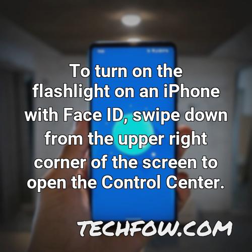 to turn on the flashlight on an iphone with face id swipe down from the upper right corner of the screen to open the control center