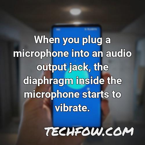 when you plug a microphone into an audio output jack the diaphragm inside the microphone starts to vibrate