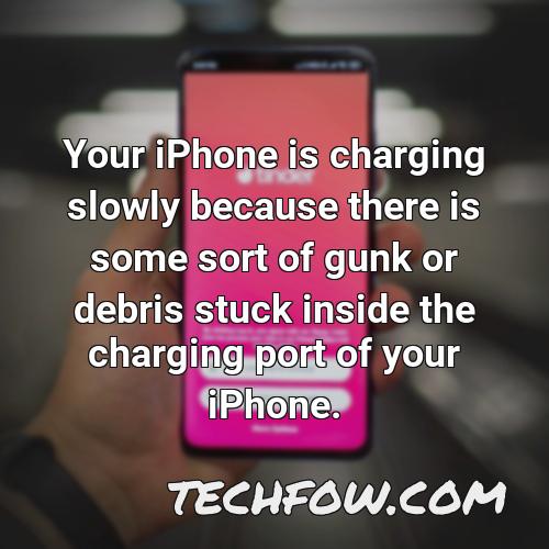 your iphone is charging slowly because there is some sort of gunk or debris stuck inside the charging port of your iphone